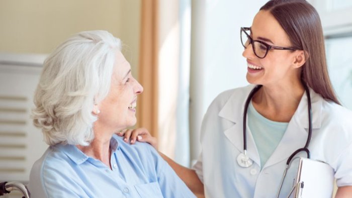 Young woman health professional comforting senior patient