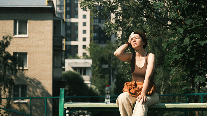 Woman resting on a bench in the hot sun