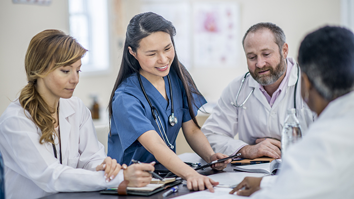 Young nurse in training with other medical professionals