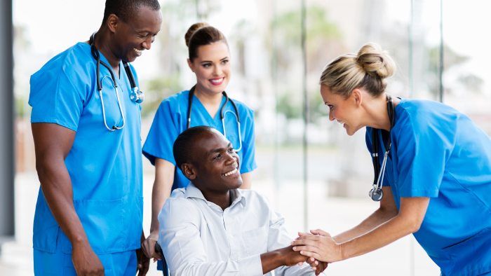 Young gentlemen in wheelchair with three diverse health care professionals