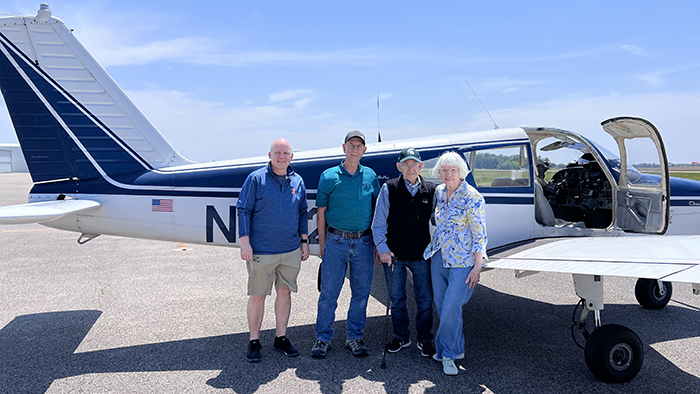 Jerry standing with family in front of plane