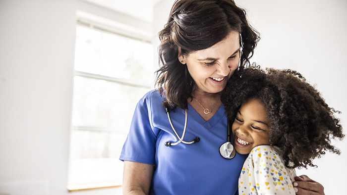 Female nurse hugging a young girl