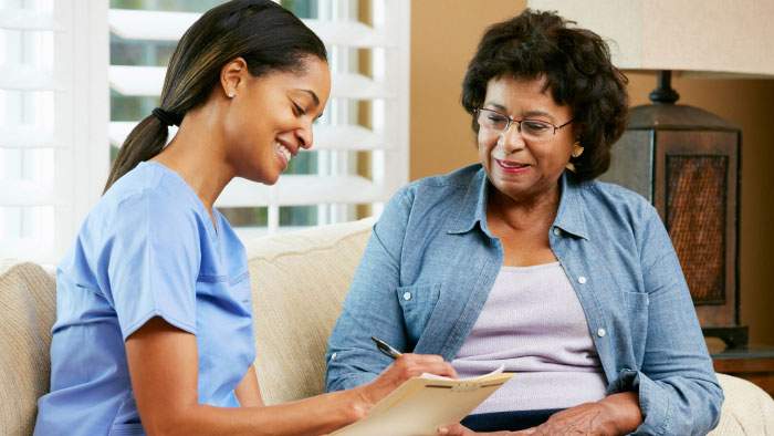 Female nurse with female patient in her home