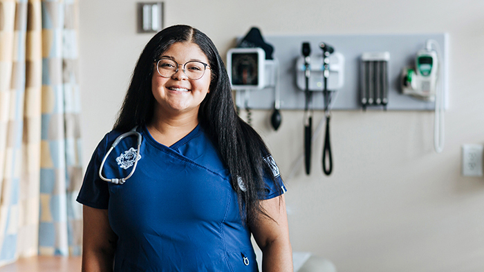 Female nursing student with hospital setting in background