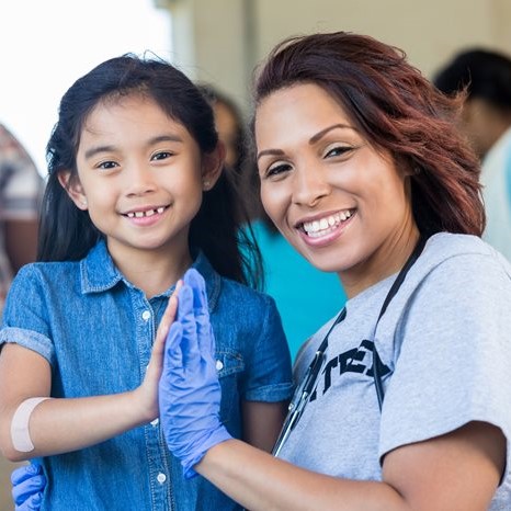 Mission Outreach provider high fives little girl