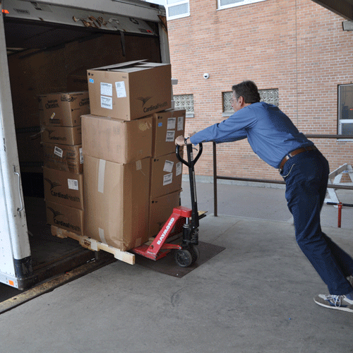 A man in blue loads a pallet of donated items onto a truck for Hospital Sisters Mission Outreach