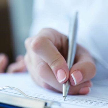 Close up of hand taking notes with a pen