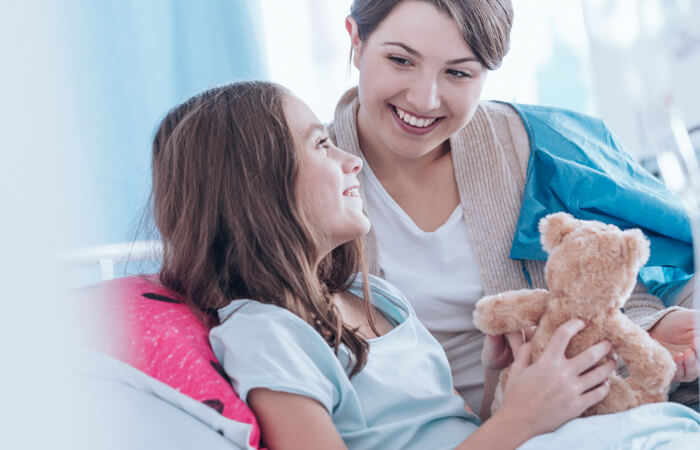 Young girl in holding bear with mom