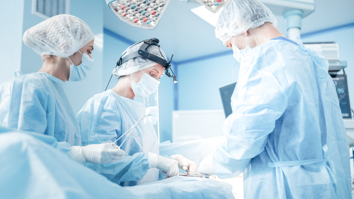 Group of 3 surgeons in an operating room