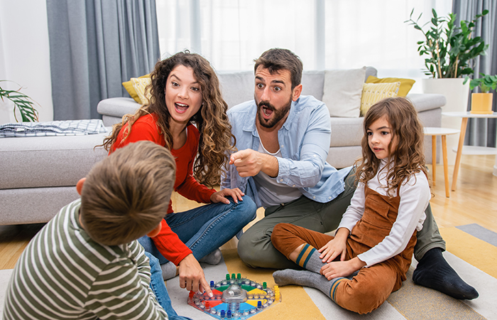 Young family of four playing a board game