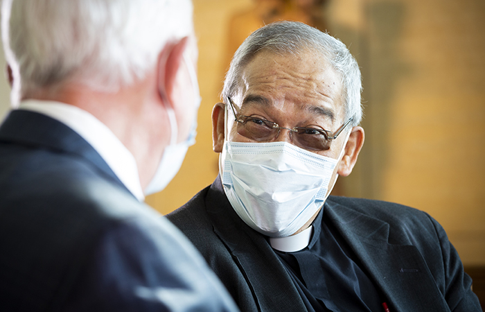 Clergyman in chapel speaking with man