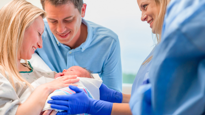 New mom and dad with newborn infant in mom's arms