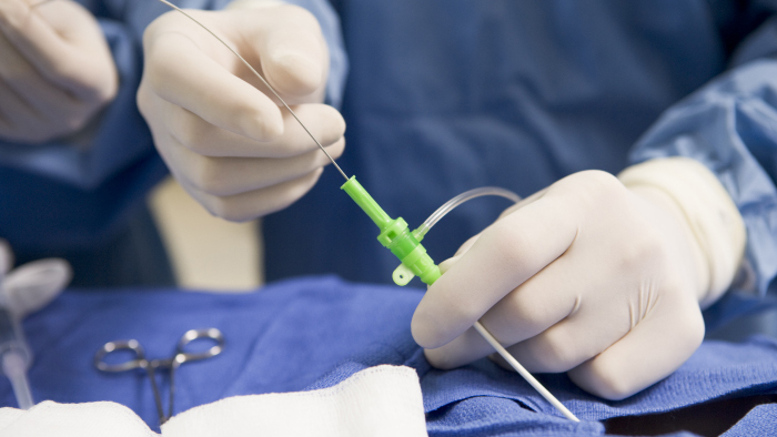 Surgeon hands performing cardiac cath