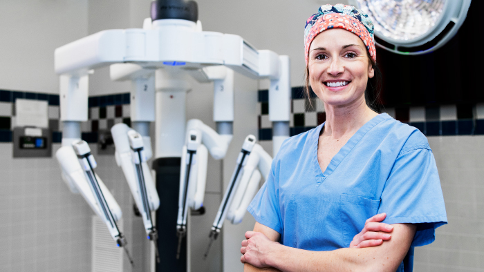 Female surgical nurse standing in front of DaVinci surgical system