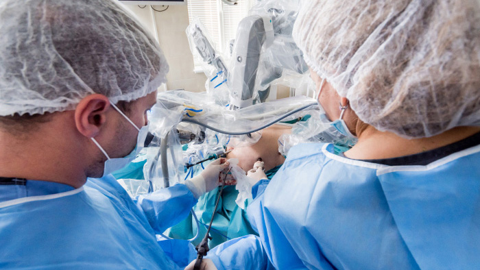 Surgeons using robotic technology on a patient