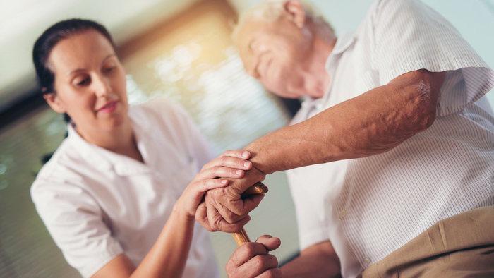 Older man with cane working with therapist