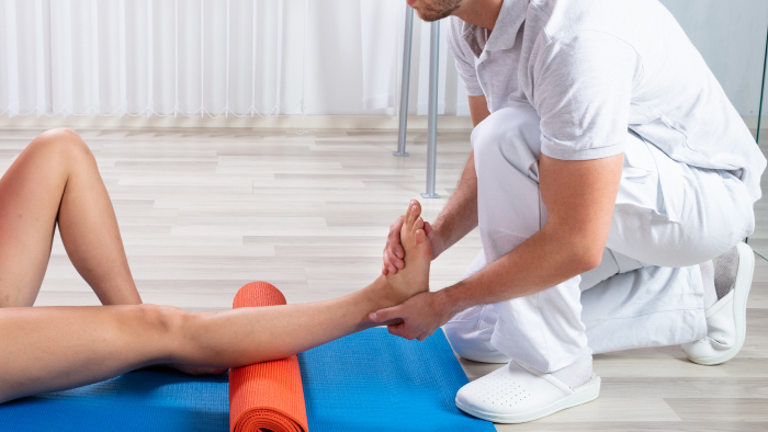 Girl stretching legs working with therapist