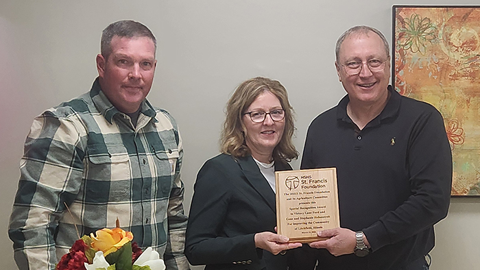 Eric Helgen, HSHS St. Francis Hospital Foundation Agriculture Committee member, presents the Special Recognition award to Victory Lane Ford owners Stephanie and Gene Hebenstreit.