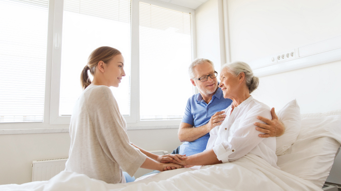 Woman patient with husband by her side and caring nursing staff