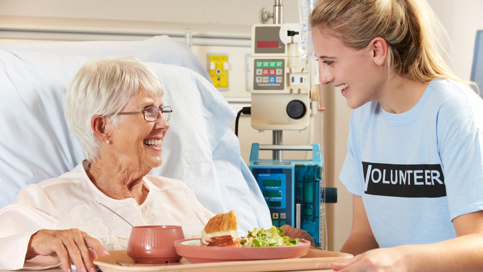 Teen volunteer talking with a woman patient