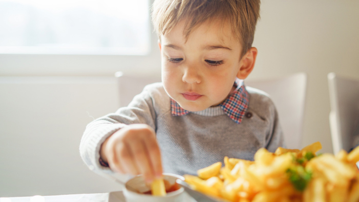 Young boy enjoying french fries