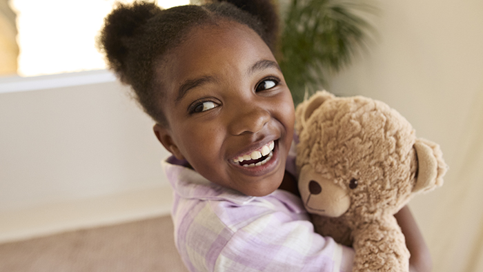 Young girl hugging her teddy bear
