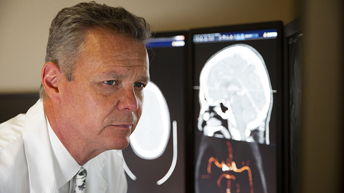 Male doctor in front of a medical scan