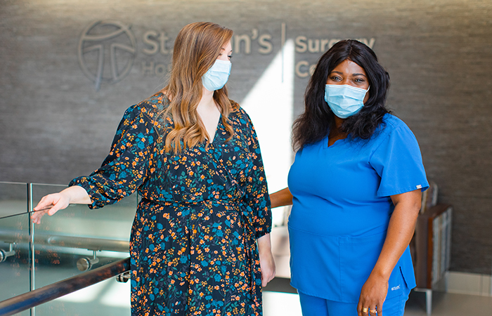 Young woman standing with female nurse