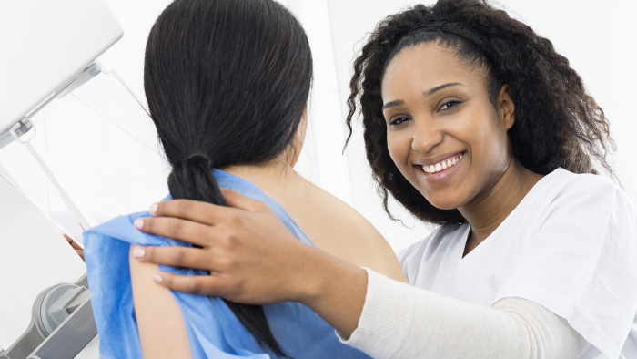 Female mammography technician performing a mammogram