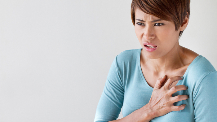 Woman clutching chest in pain
