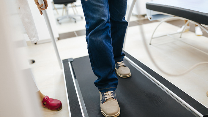 Legs of man walking on treadmill