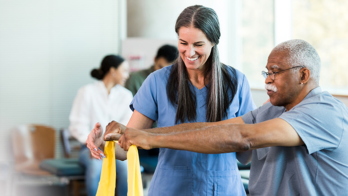 Female therapist performing occupational therapy with older man