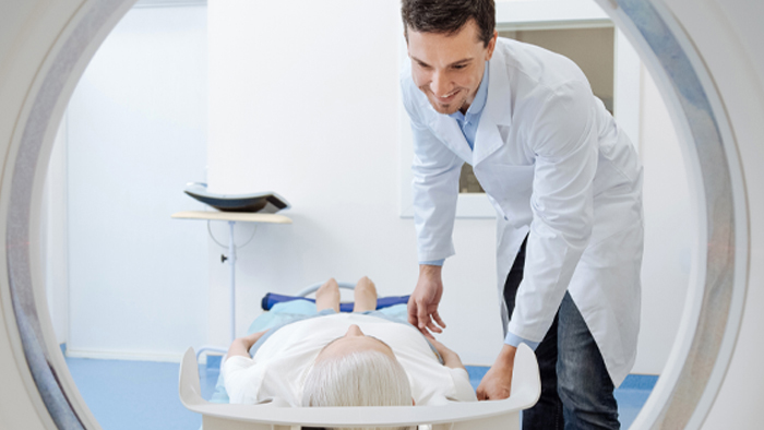 Technician moving a patient into CT machine