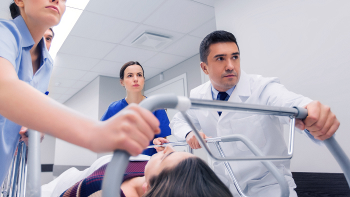 Emergency room doctor and nurses pushing hospital bed