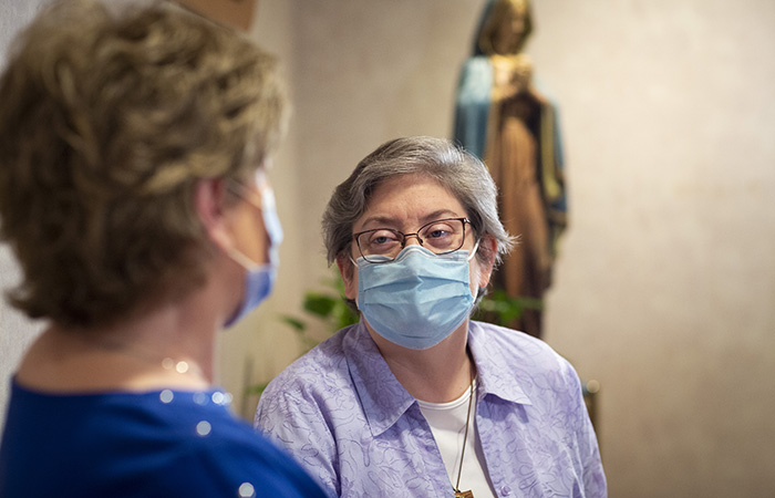 Pastoral care colleague speaking with woman in chapel