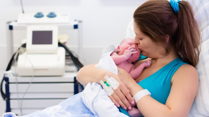 New mom with baby in her arms giving him a kiss