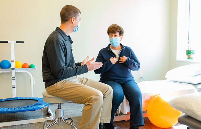 Male physical therapist coaching a female patient