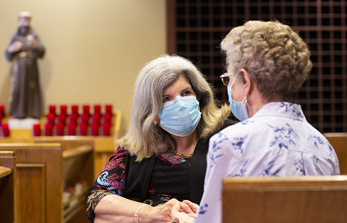 Pastoral care colleague speaking with woman in chapel