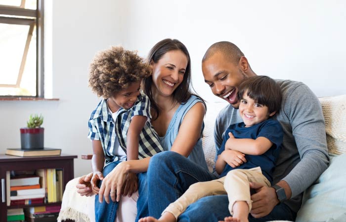 Diverse family laugh together while sitting on a couch