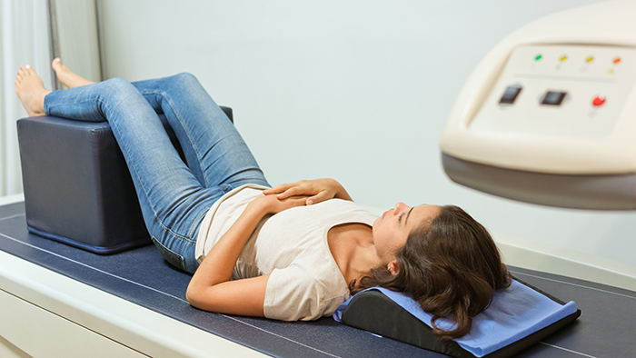 Woman laying on diagnostic table for bone density test