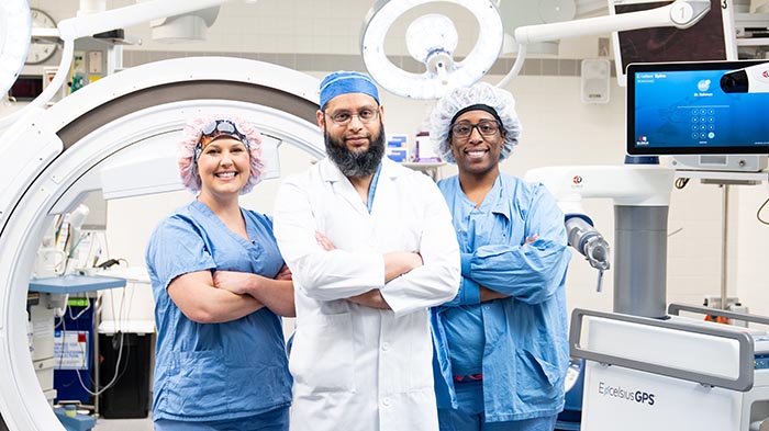 Surgeon and team in front of robotic surgical system