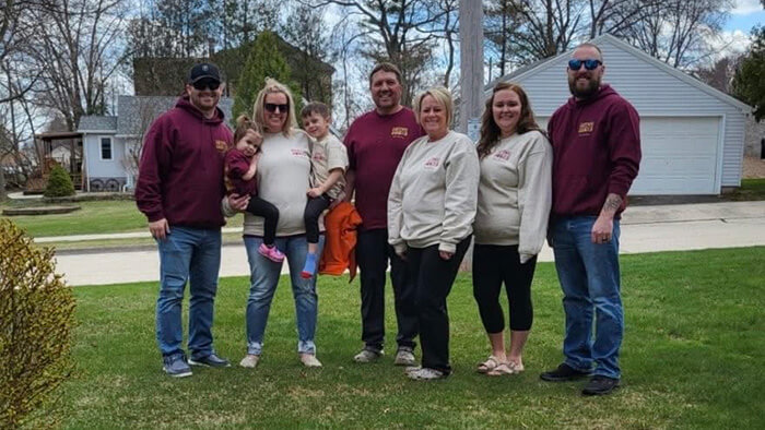 Courtney, second from right, poses for a photo with her husband and his family in their custom apparel supporting Courtney's journey.