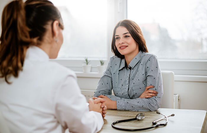 Dietician sits at desk and talks to female patient