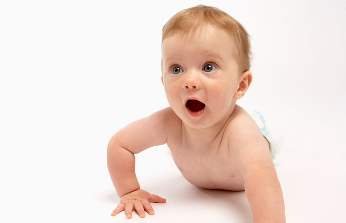 white infant crawling while making a surprised face