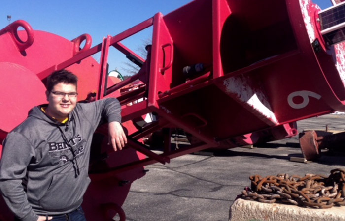 Sten posing in front of a machine outside