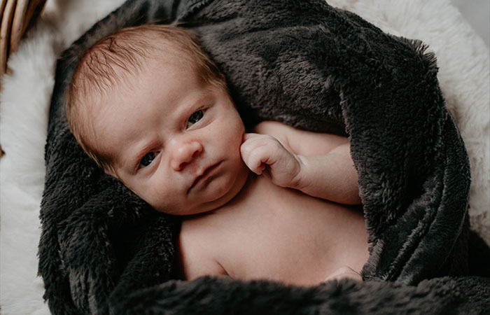 Baby Wally bundled in a blanket looking at the camera