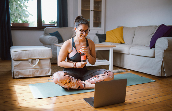 Woman doing yoga via computer