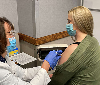 Nurse Kayla Kennedy receiving COVID-19 vaccine
