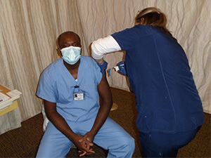 Dr. Charles Korankye receiving COVID-19 vaccine