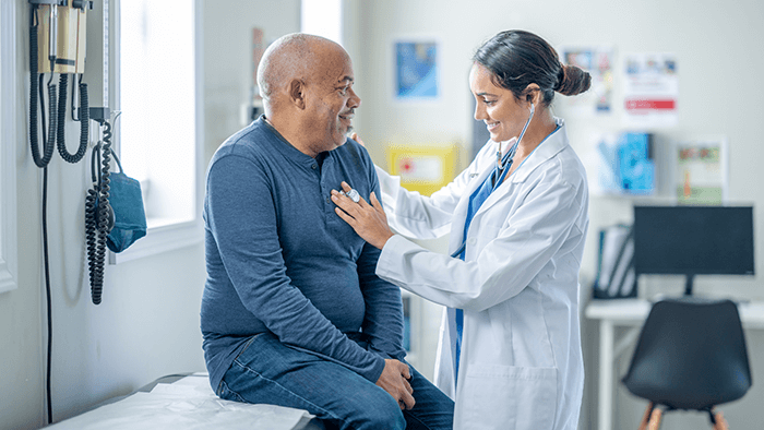 Doctor listening to a patient’s heartbeat with a stethoscope during a checkup.